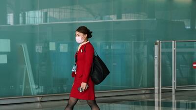 A Cathay Pacific employee, wearing a face mask to protect against the coronavirus, walks past the departures hall at Hong Kong International Airport in Hong Kong, China. Reuters
