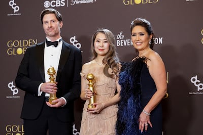 From left: Chris Appelhans, Maggie Kang, and Michelle Wong pose with the Best Motion Picture - Animated award for KPop Demon Hunters. Reuters