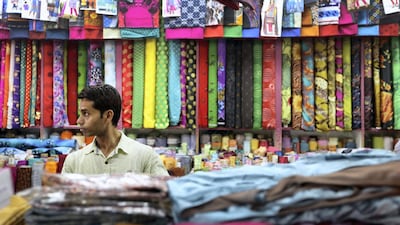A man arranges fabric at a store in Satwa in Duba. many such stores are family run businesses that have been passed down generations. Francois Nel/Getty
