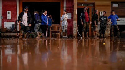 People clean their houses affected by floods in Utiel, Spain. AP