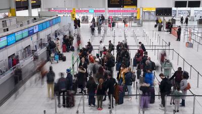 Passengers check in at the South Terminal of London Gatwick Airport in West Sussex. PA