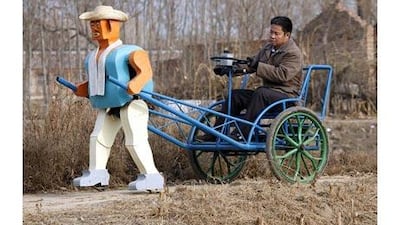 The Chinese inventor, Wu Yulu, whose creations are constructed using scrap metal, operates his robot-powered rickshaw. Reinhard Krause / Reuters