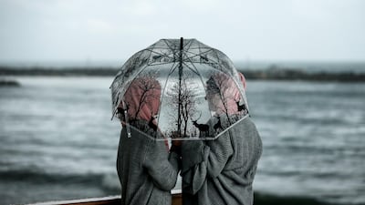 Palestinian girls stand under an umbrella during a rainy day in Gaza City. AFP