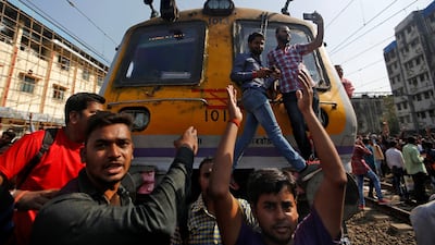 People shout slogans as they block train services during a protest demanding recruitment into the railway services in Mumbai in March. Unemployment rate in India was high even before pandemic wiped out millions of jobs in the country. Reuters