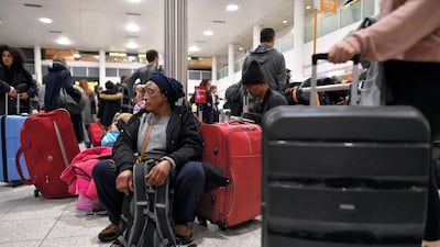 Passengers sit with their luggage in the South Terminal building at London Gatwick Airport, south of London, on December 21, 2018, as flights started to resume following the closing of the airfield due to a drone sightings. AFP