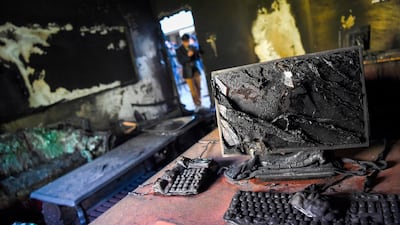 A photographer takes pictures inside a burned office of the National Legal Training center a day after gunmen stormed the university in Kabul. AFP