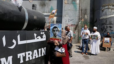 A woman holds a picture of a jailed Palestinian during a rally in support of Palestinian prisoners held in Israeli jails, in the West Bank town of Bethlehem. Ammar Awad / Reuters