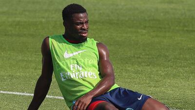 Ivory Coast defender Serge Aurier sits on the ground during a training camp in the Qatari capital Doha, on December 28, 2015. AFP PHOTO / KARIM JAAFAR