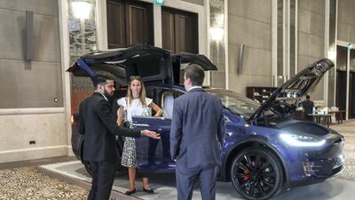 Visitors to the conference look at a Tesla Model X. Victor Besa / The National