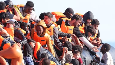 Migrants struggle to board a people-smugglers' boat on July 29 in an attempt to cross the English Channel, off the beach of Gravelines, northern France. AFP
