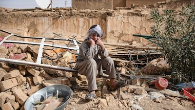 An earthquake survivor sits in the remains of a house in a village in Tashqurghan, Afghanistan. AFP