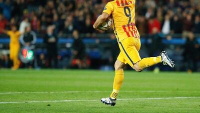 Barcelona’s Uruguayan forward Luis Suarez (C) runs with the ball after scoring during the Uefa Champions League quarter finals first leg football match FC Barcelona v Atletico Madrid at the Camp Nou stadium in Barcelona on April 5, 2016. AFP / PAU BARRENA