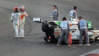 Marshals deal with the wreckage from Michael Schumacher’s crash with Vitatonio Liuzzi last year.