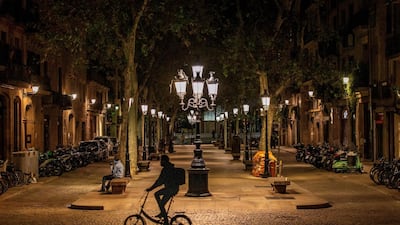 A man rides his bike along the empty Passeig del Born avenue during a curfew in Barcelona, Spain. EPA