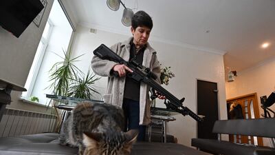 TOPSHOT - Mariana Jaglo, mother-of-three, holds her Ukrainian Z-15 - Zbroyar long rifle during an interview in the kitchen of her flat in Kiev. - As fears grow of a potential invasion by Russian troops massed on Ukraine's border, this 52-year-old army reservist, insists in her willing to fight to defend her country. AFP
