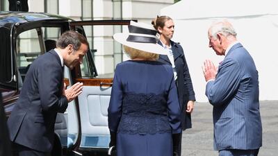 French president Emmanuel Macron says goodbye with a namaste gesture to the Britain's Prince Charles, Prince of Wales, right, and Britain's Camilla, Duchess of Cornwall after a ceremony at the statue of former French president Charles de Gaulle at Carlton Gardens in central London. AFP