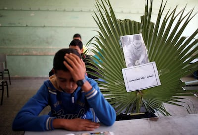 A picture of 14-year-old Palestinian boy Khaled Saed, who was killed with other two boys in an Israeli air strike on the Gaza Strip frontier, is seen on his chair as his classmates react at a school. Reuters