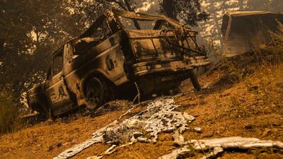 A destroyed vehicle sits amongst the rubble of a burned home along Empire Flat Road. Bloomberg