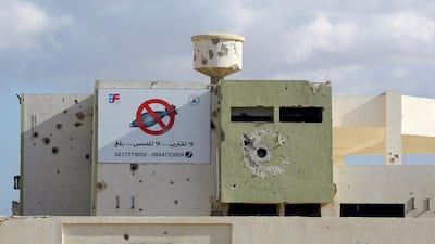 A rocket-riddle building with a sign in Arabic calling for people to stay away from unexploded devices is seen in Tawergha, 260 km east of the Libyan capital Tripoli. AFP