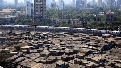 A train passes through slum area of Mumbai, a city that is too costly for the many poor people living there. The government now says affordable housing will receive infrastructure status. Rajanish Kakade / AP Photo