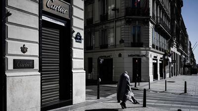 This picture taken on March 23, 2020 shows a homeless person walking down the deserted Champs Elysees in Paris, during the strict lockdown in France to stop the spread of the COVID-19 novel coronavirus. / AFP / Philippe LOPEZ