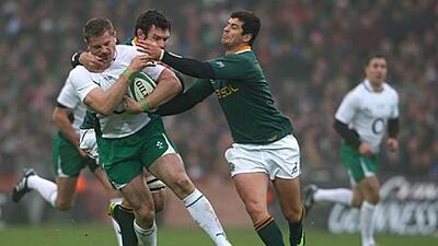 Ireland's Jamie Heaslip is tackled by Danie Rossouw and Mourne Steyn of South Africa.
