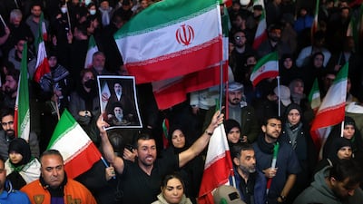 Iranians wave flags at a demonstration following the announcement of a two-week ceasefire, at Enghelab Square in Tehran. EPA