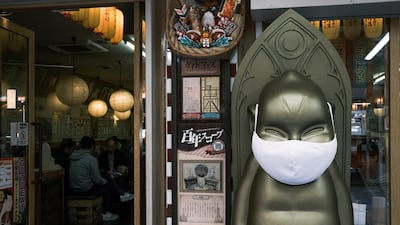 A statue in front of a restaurant wears a protective mask in the Shinsekai shopping district of Osaka, Japan. Bloomberg