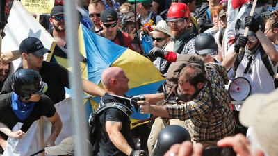 White nationalist demonstrators clash with counter demonstrators at the entrance to Lee Park in Charlottesville. Police dressed in riot gear ordered people to disperse after chaotic violent clashe. Steve Helber / AP