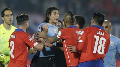 Edinson Cavani, centre, argues with Gonzalo Jara, right, after the incident that saw the Uruguay striker sent off. Ricardo Mazalan / AP Photo