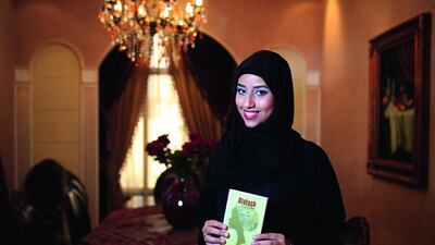 The author Alia Al Hazami, with her book Alatash, which she completed while at high school. Sarah Dea / The National