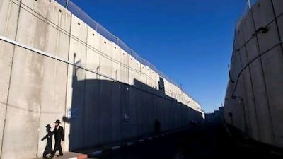 An ultra-Orthodox Jewish man walks past a section of the controversial Israeli barrier in Bethlehem. Israeli Jews were riled by last week’s suggestion from poll results that they have built an ‘apartheid state’ on Palestinian territory.