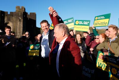 Plaid Cymru Leader Rhun ap Iorwerth (centre left) lifts the arm of Plaid Cymru's newly elected Senedd member Lindsay Whittle as they celebrate at Caerphilly Castle after victory for the party in the Caerphilly Senedd by-election, on October 24. PA