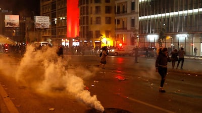Protesters cover their faces from the tear gas that fired by the riot police during an anti-government protest in Beirut, Lebanon. AP Photo