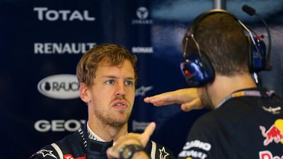 Sebastian Vettel talks to team mates in the pits during the second practice session. Marwan Naamani /AFP