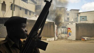 Police guard the Salvation Army Church after it was set on fire during riots in Mombasa on Friday. AP Photo