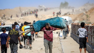 A man carries firewood on his shoulders past people making their way to Gaza city. AFP