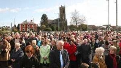 Members of a Catholic church gather to pray near the scene of a sectarian shooting that killed two British Soldiers in Northern Ireland.