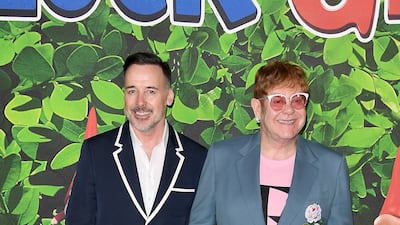 David Furnish and Elton John, in a grey suit with a pink T-shirt, attend the 'Sherlock Gnomes' family gala at Cineworld Leicester Square, London on April 22, 2018. Getty Images