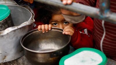 Palestinian children wait to receive food cooked by a charity kitchen amid shortages of food supplies, in Rafah, in the southern Gaza Strip, on February 13. Reuters