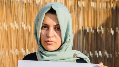 A campaigner holds a placard to raise awareness of violence against women in Afghanistan.