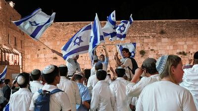 Members of Israeli youth movements dance and wave flags. AP