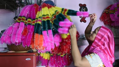 A worker arranges garlands made from coloured polyster/silk yarn ahead of the Hindu festival of Diwali in Ahmedabad on October 17, 2019. Colourful garlands are in demand during the Hindu festival of Diwali, or Festival of Lights, which falls on October 27 this year. Photo: AFP