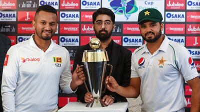 Pakistan captain Azhar Ali (R) and Sri Lankan counterpart Dimuth Karunaratne pose for a photograph with the Test series trophy at the Pindi Cricket Stadium ahead of the first Test in Rawalpindi. AFP