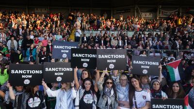 Fans hold up signs calling for sanctions against Israel at half-time in Dublin. PA