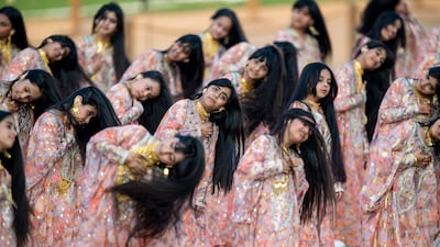 Emirati girls perform a hair dance at the annual parade