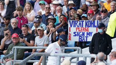 A young fan holds a placard as Virat Kohli walks back after losing his wicket. AP