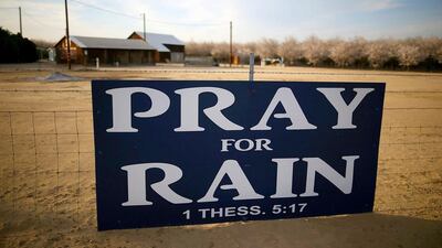 A farmer in Turlock, California turns to heaven after the sky fails to provide him rain to water his crops. Justin Sullivan / Getty Images / AFP