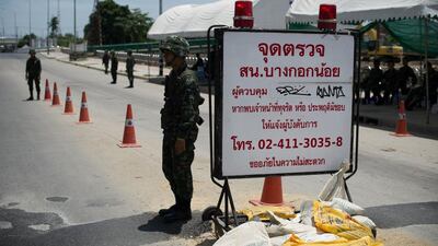Thai army soldiers stand at a checkpoint near where pro-government “Red shirts” have been rallying for days on the outskirts of Bangkok. Nicolas Asfouri / AFP Photo