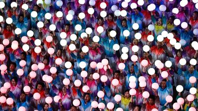 Performers hold light bulbs at the Asian Culture Carnival at the National Stadium in Beijing, China. EPA